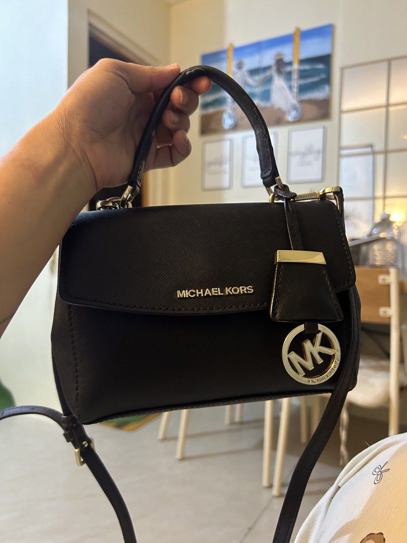 Michael Kors Black Crossbody Handbag (Category: Cross-body Bags) located in Manila. Submitted by gleglessie (Listing ID 1464928941, Image 1). Description: - Authentic black Michael Kors structured handbag - Made from scratch-resistant Saffiano leather with gold-tone hardware - Versatile design with top handle and a removable shoulder strap - Secure flap closure with magnetic side snap buttons - MK logo-lined interior featuring an inner zip pocket