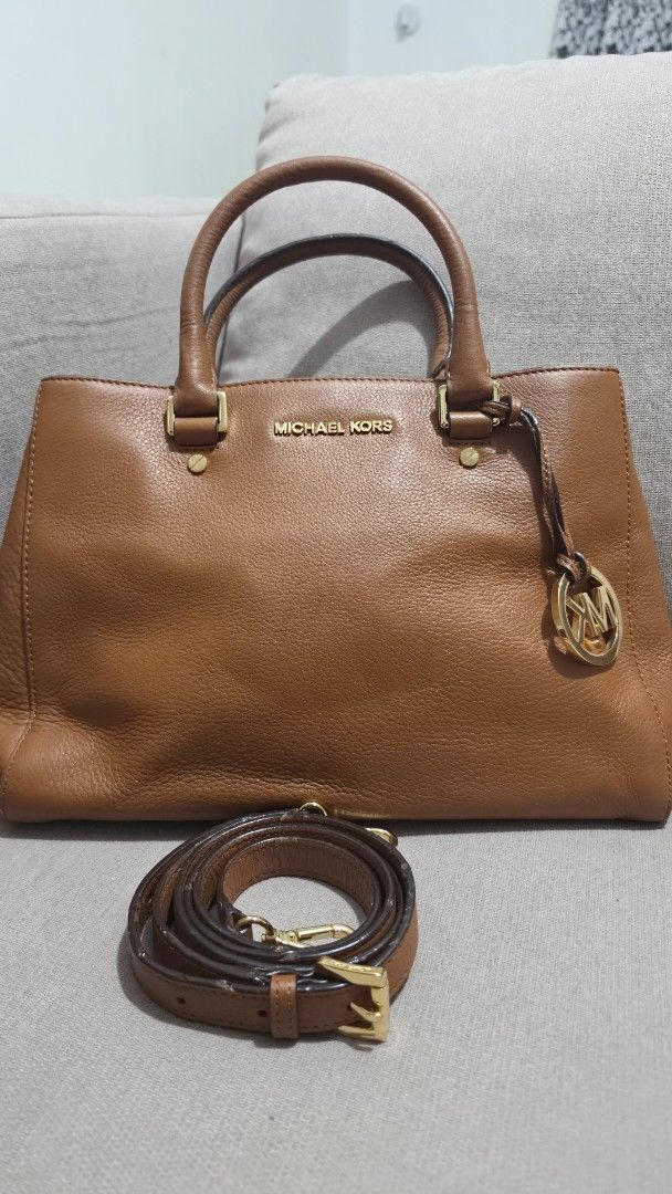 Michael Kors Brown Leather Tote Handbag with Strap (Category: Shoulder Bags) located in Makati City. Submitted by edgeeh (Listing ID 1464912996, Image 3). Description: - Brand: Michael Kors - Material: Rich brown pebbled leather with clean grain texture - Hardware: Premium gold-tone hardware with iconic MK circle logo charm - Carry Options: Dual top handles and a detachable, adjustable shoulder strap - Protection: Metal feet on the bottom panel t