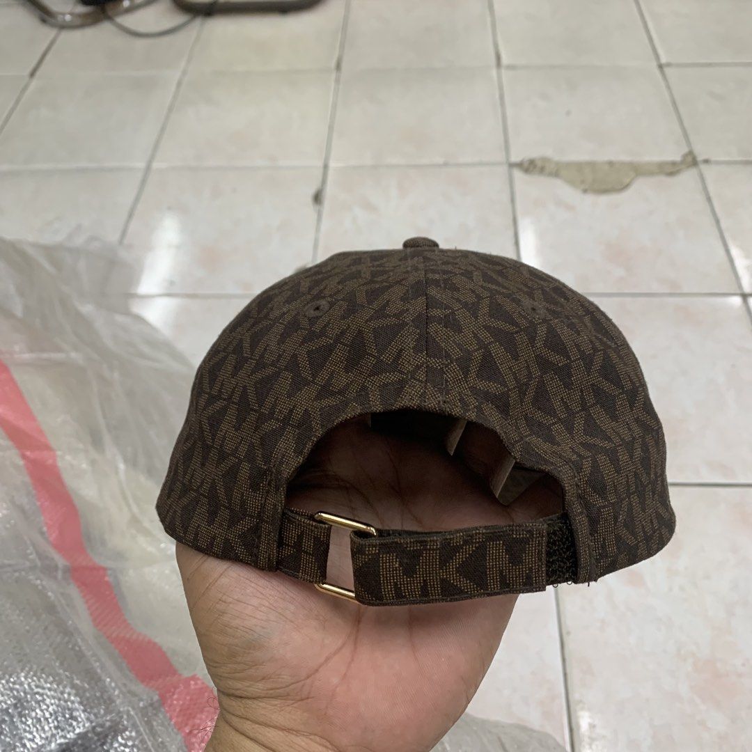 Michael Kors Brown MK Monogram Baseball Cap (Category: Caps & Hats) located in Cebu City. Submitted by jkeive (Listing ID 1464831601, Image 3). Description: - Brand: Michael Kors - Design: All-over signature monogram print in brown - Material: 100% cotton shell and lining for breathable comfort - Fit: Adjustable back strap with a branded gold-tone metal buckle - Details: Interior branded taping and sewn-in care label - Care Instructions: Hand was