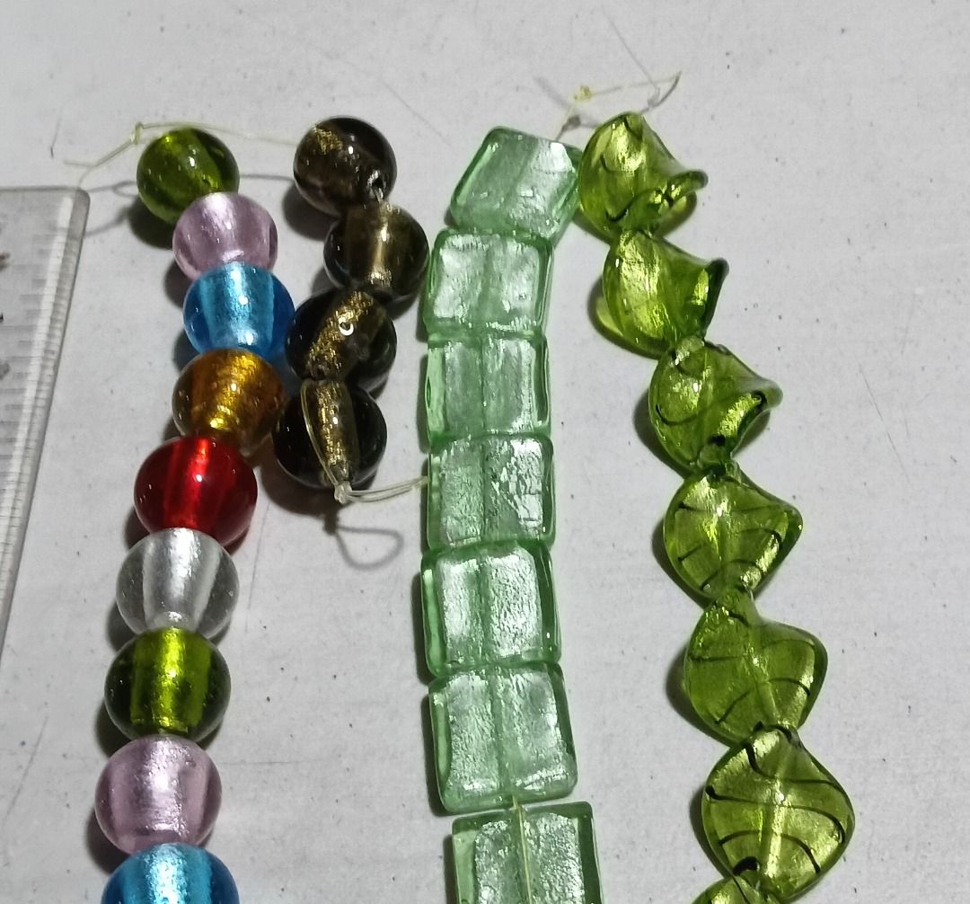 Mixed Murano-Style Glass Beads Strand Bundle (Category: Craft Supplies & Tools) located in Marikina City. Submitted by my-an (Listing ID 1464915541, Image 1). Description: Mixed Murano-Style Glass Beads Strand Bundle - 4 strands of assorted craft beads for DIY jewelry making - Includes round multicolored foil glass beads and dark gold-flecked round beads - Features pale green square tube beads and twisted leaf-shaped green beads - Strung on thin 