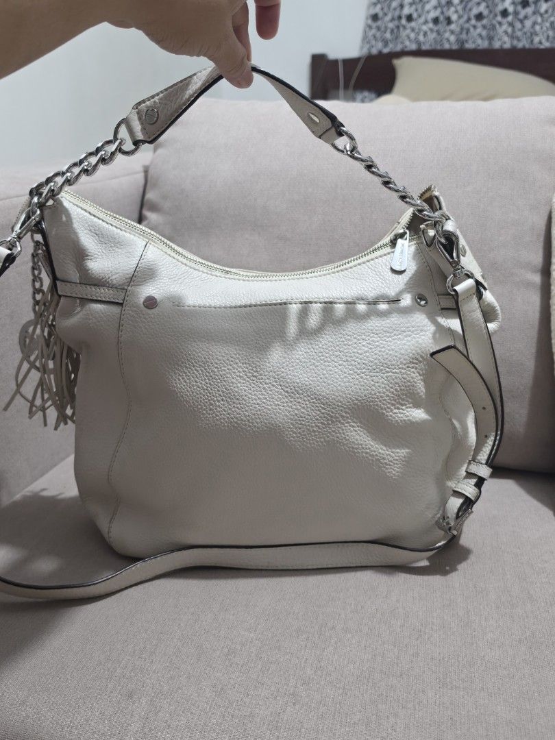 MK White Leather Shoulder Bag with Chain Strap (Category: Shoulder Bags) located in Makati City. Submitted by edgeeh (Listing ID 1464912171, Image 2). Description: White leather hobo bag by Coach. Silver-tone chain detail on the top handle, plus a longer adjustable strap. Zipper closure across the top. Fringe tassel hanging off the side. Clean pebble grain texture all over. Roomy interior for daily essentials..