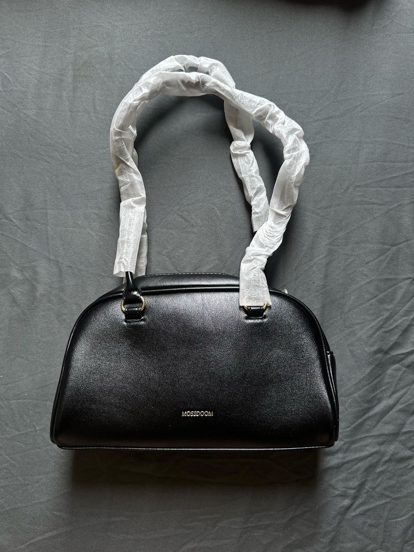 MOSSDOOM Black Shoulder Bag (Category: Shoulder Bags) located in Manila. Submitted by shopwmsl123 (Listing ID 1464785941, Image 3). Description: - Brand: MOSSDOOM - Color: Clean black with chic gold-tone hardware - Style: Shoulder bag - Pockets: Front zip closure pocket and small flap pocket - Condition: Brand new with tag attached - Extra: Handles still wrapped in original protective paper.