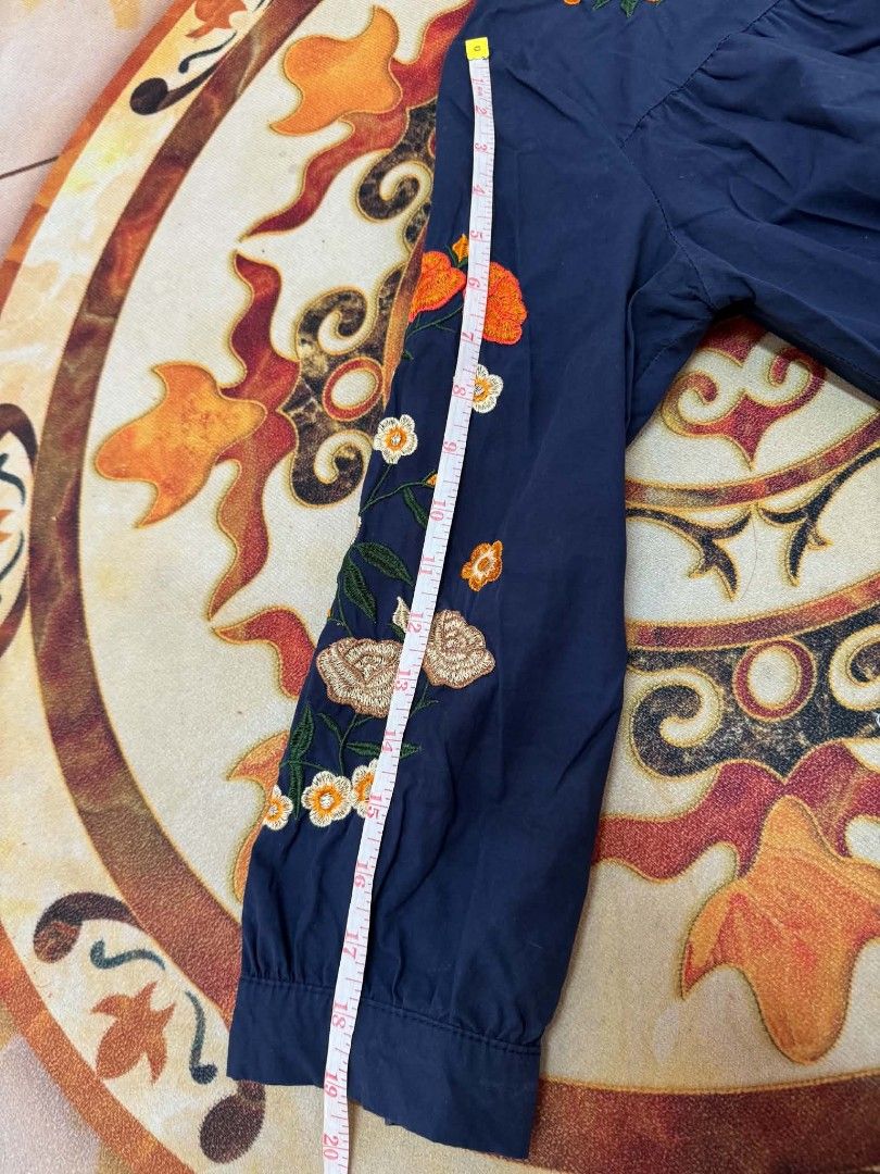 Navy Blue Floral Embroidered Button-Down Blouse (Category: Dresses) located in Caloocan City. Submitted by mylove326 (Listing ID 1464920966, Image 3). Description: - Color: Dark blue with colorful floral embroidery - Style: Button-down with a mandarin collar and loose fit - Details: Gathered accents at the chest and back - Measurements: Approx. 30 inches length, 19 inches sleeves - Material: Soft fabric, perfect for pairing with jeans or skirts S