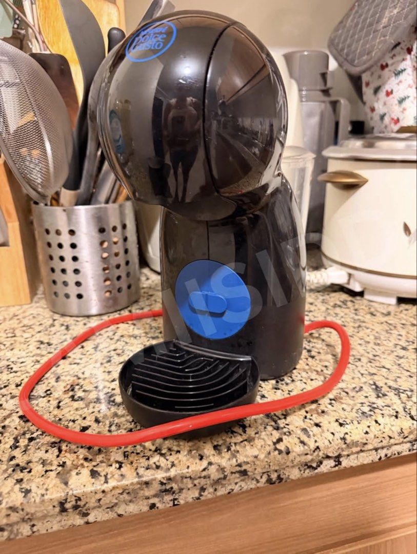 Nescafe Dolce Gusto Piccolo XS (Category: Coffee Machines & Makers) located in Las Pinas. Submitted by camiisidd (Listing ID 1464966170, Image 1). Description: - Model: Nescafé Dolce Gusto capsule coffee machine - Color: Sleek black with a vibrant red power cord - Design: Compact space-saving size, perfect for any kitchen countertop - Features: Simple blue button control, rear water tank, removable drip tray, and capsule holder - Function: Makes 