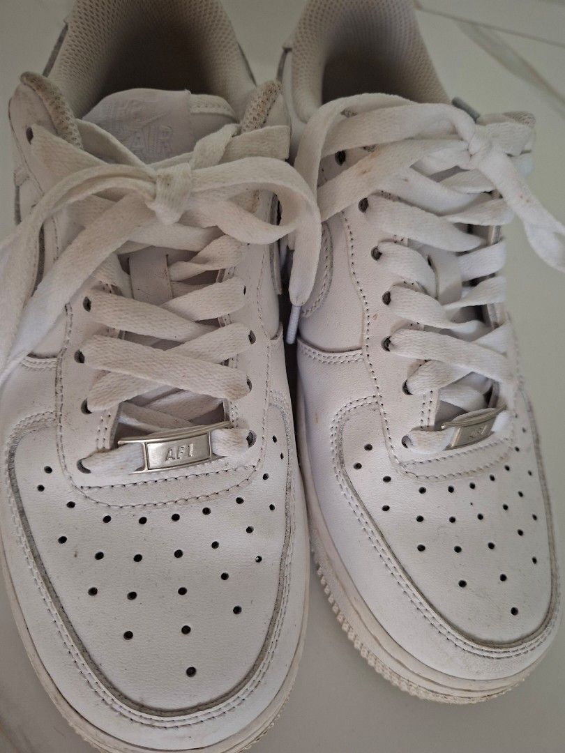 Nike Air Force 1 White Low Sneakers (Category: Sneakers) located in Angeles City. Submitted by miho066_ (Listing ID 1464770940, Image 3). Description: - Authentic Nike Air Force 1 Low top sneakers in classic white - Iconic chunky silhouette with breathable perforated toe box - Premium white leather upper with matching laces and silver AF1 lace dubraes - Durable rubber sole with solid traction - Condition: Regular wear with minor creasing and dust