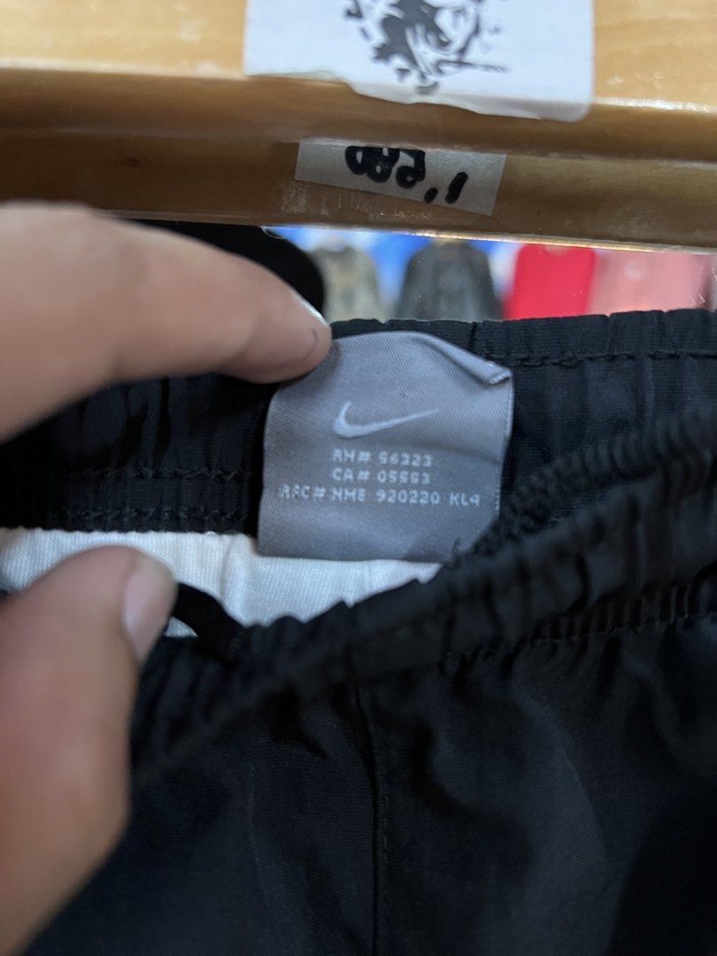 Nike Black and White Track Pants Size M (Category: Joggers) located in Baguio. Submitted by thrash2cash_2600 (Listing ID 1464867580, Image 3). Description: - Brand: Nike - Style: Track pants with white side panels and embroidered swoosh logo - Size: Medium (Made in Thailand) - Material: Lightweight nylon - Fit: Relaxed fit with elastic waistband and adjustable drawstring.