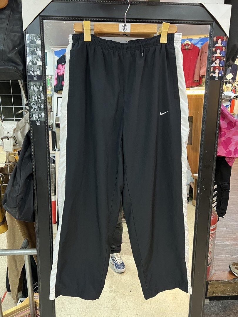 Nike Black and White Track Pants Size M (Category: Joggers) located in Baguio. Submitted by thrash2cash_2600 (Listing ID 1464867580, Image 1). Description: - Brand: Nike - Style: Track pants with white side panels and embroidered swoosh logo - Size: Medium (Made in Thailand) - Material: Lightweight nylon - Fit: Relaxed fit with elastic waistband and adjustable drawstring.