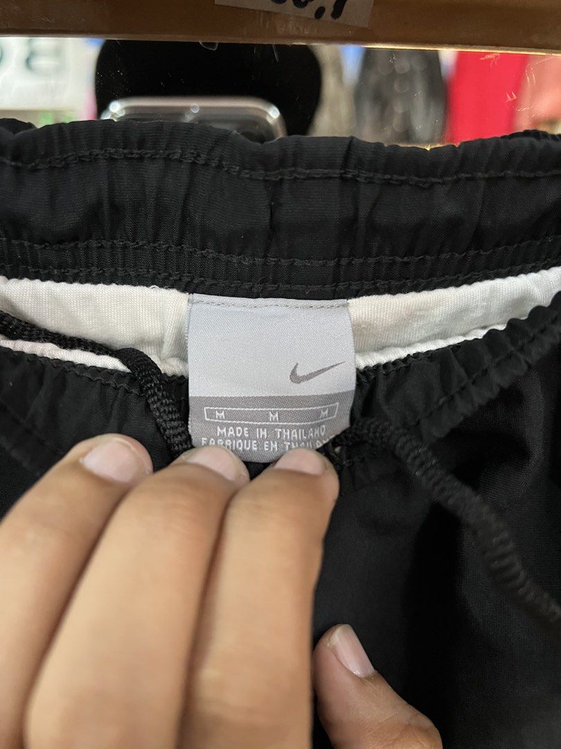 Nike Black and White Track Pants Size M (Category: Joggers) located in Baguio. Submitted by thrash2cash_2600 (Listing ID 1464867580, Image 2). Description: - Brand: Nike - Style: Track pants with white side panels and embroidered swoosh logo - Size: Medium (Made in Thailand) - Material: Lightweight nylon - Fit: Relaxed fit with elastic waistband and adjustable drawstring.