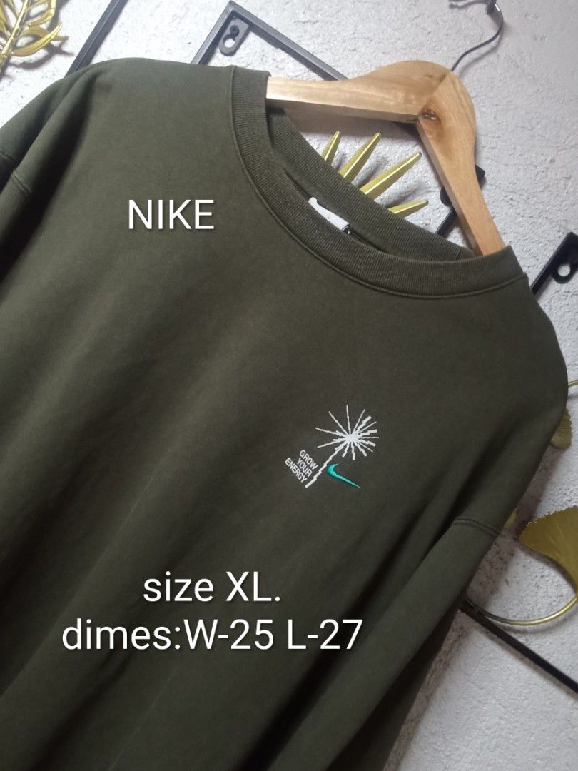 Nike Crewneck Army Green (Category: Coats, Jackets and Outerwear) located in Kawit. Submitted by deidzdzn (Listing ID 1464796395, Image 2). Description: - Brand: Nike - Style: Grow Your Energy Crewneck Sweatshirt - Color: Army Green - Design: Embroidered dandelion and Nike logo graphic on the chest - Fit: Relaxed fit with ribbed collar, cuffs, and hem - Size: XL - Measurements: Width 25 inches, Length 27 inches.