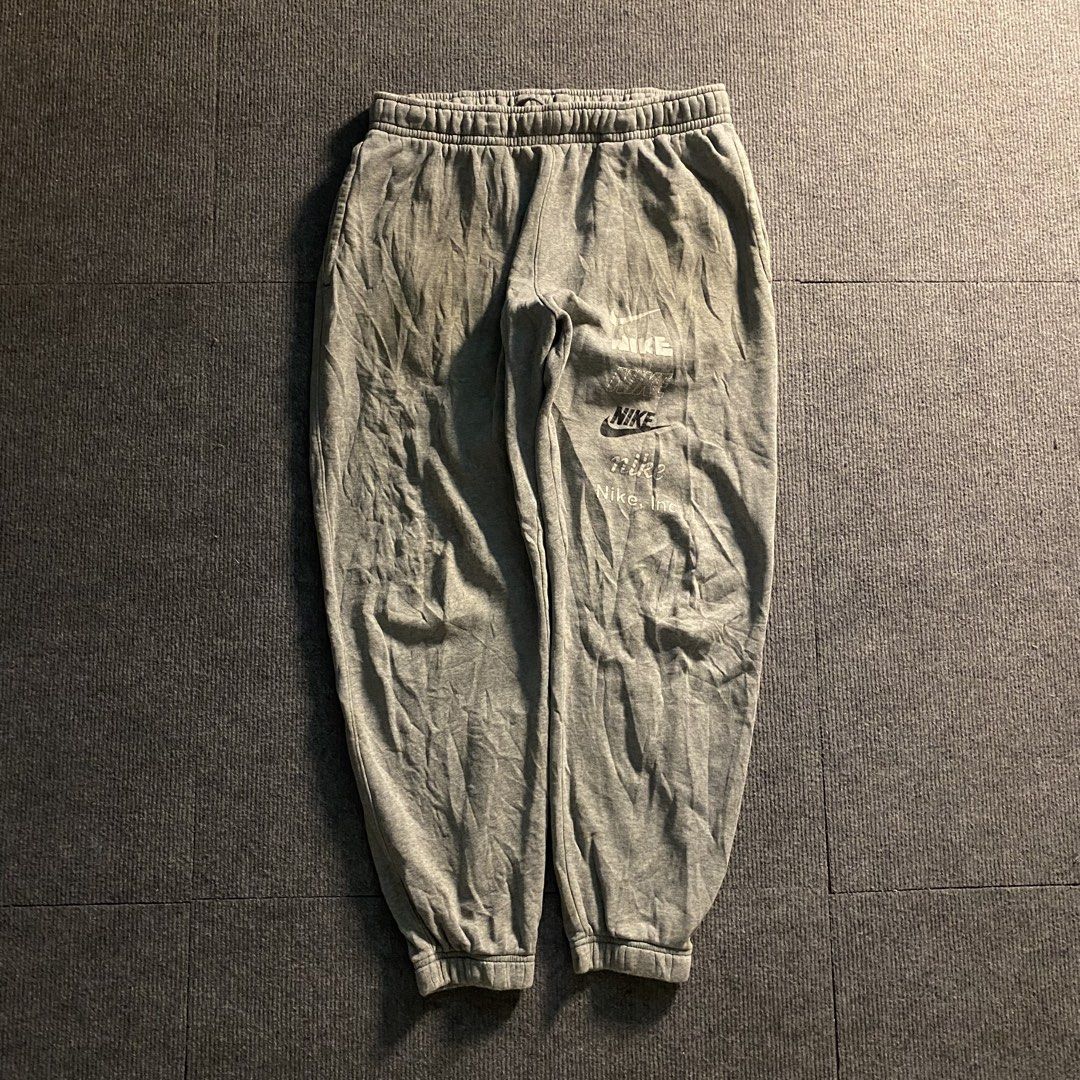 Nike grey sweatpants with logo stack (Category: Joggers) located in Malaybalay. Submitted by mat.loots (Listing ID 1464822816, Image 1). Description: - Brand: Nike - Color: Grey - Size: Large - Design: Multiple stacked Nike logo graphics on the left leg - Material: Thick fleece inside (super warm and cozy) - Fit: Elastic waistband with adjustable drawstring and cuffed ankles - Origin: Made in Cambodia - Condition: Brand new / Excellent quality - 