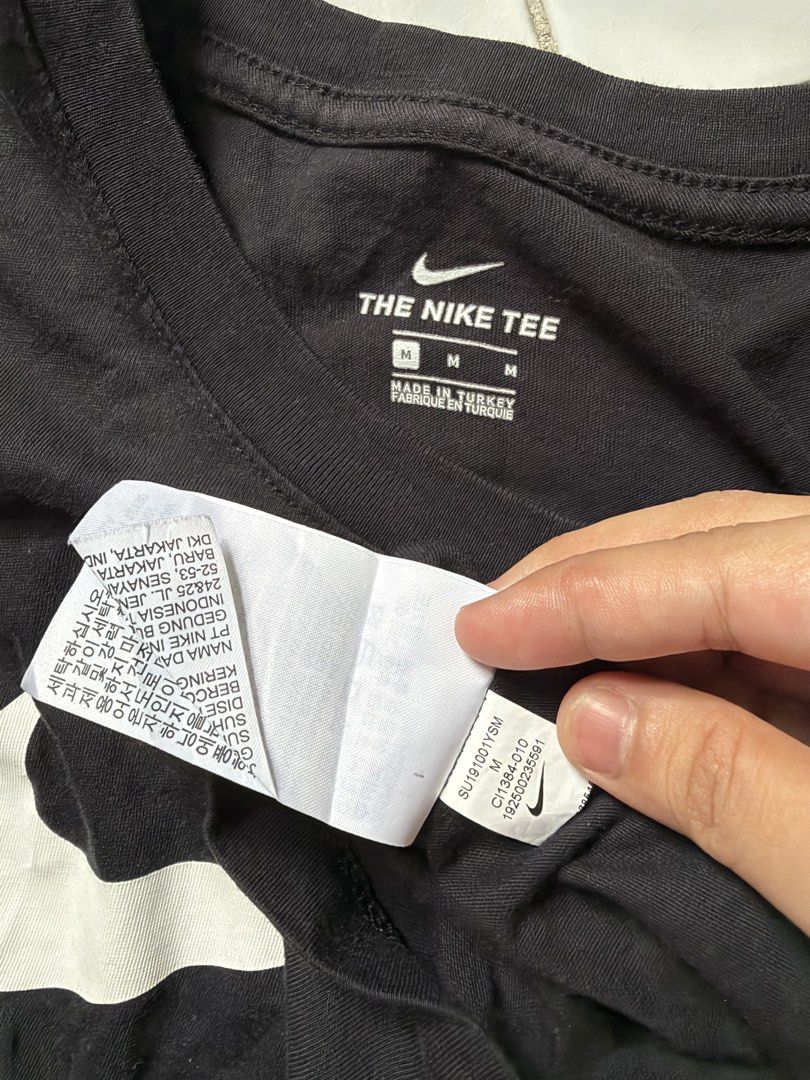 Nike Just Do It Black Tee Size M (Category: Shirts) located in Paranaque City. Submitted by yukigrace12 (Listing ID 1464799179, Image 2). Description: - Brand: Nike - Color: Black - Size: Medium (The Nike Tee) - Design: Large white Swoosh graphic with 'JUST DO IT.' text on the chest - Details: Round collar, made in Turkey - Product Code: CI1384-010 - Condition: Clean fabric with standard wear.