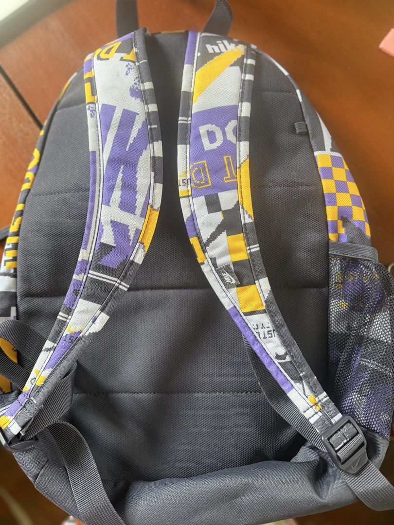 Nike Retro Pixel Graphic Backpack (Category: Babies & Kids Fashion) located in Angeles City. Submitted by reginageorge22 (Listing ID 1464848542, Image 2). Description: - Brand: Nike - Design: All-over pixelated graphic pattern in grey, yellow, and purple - Storage: Large main compartment, front zip pocket, and mesh side pocket for water bottle - Comfort: Padded shoulder straps and back panel - Material: 100% polyester (Made in Vietnam) - Perfect 