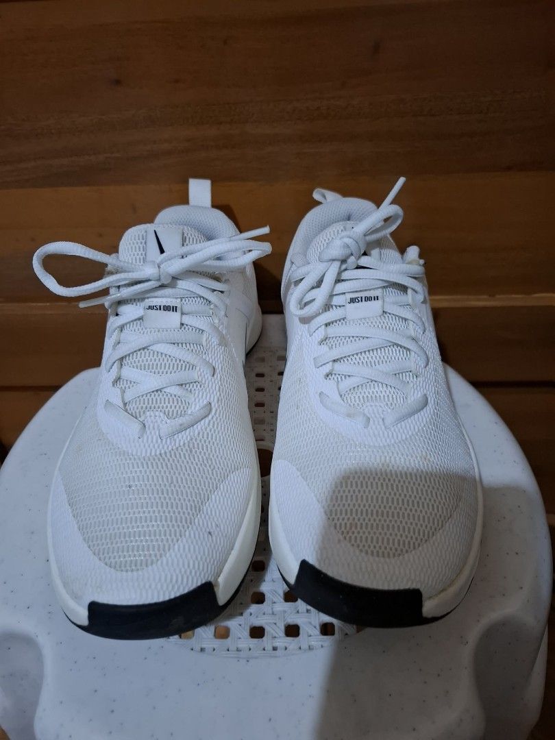 Nike White and Silver Sneakers (Category: Sneakers) located in Muntinlupa City. Submitted by googoosh_collection (Listing ID 1464771354, Image 3). Description: - Brand: Nike - Style: White mesh sneakers with silver swoosh and black rubber outsole - Details: Pull tabs at heels and 'Just Do It' text on tongue label - Closure: Lace-up - Condition: Clean white uppers, soles show minor wear with deep, intact tread - Best for: Comfortable daily trainer