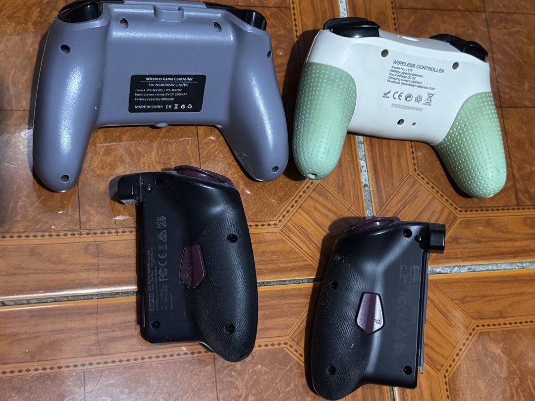 Nintendo Switch Wireless Game Controllers and Hori Grip Set (Category: Controllers) located in Pasig City. Submitted by sdpii (Listing ID 1464786985, Image 2). Description: - Complete 4-controller bundle for Nintendo Switch and PC gaming - Includes grey JYS wireless controller, white wireless controller with green silicone grips, and two Hori Monster Hunter Rise split controllers with custom thumb grips - All units tested and 100% fully functiona