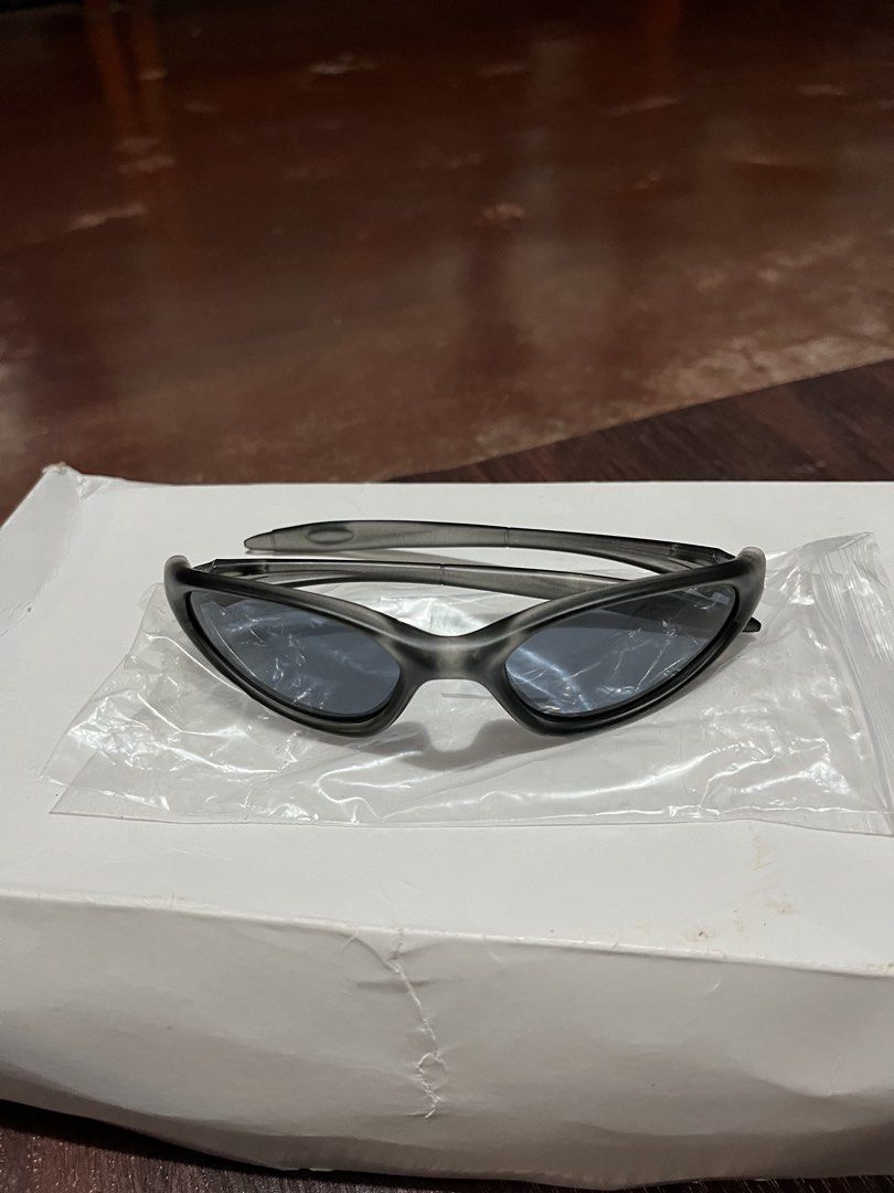 Oakley Plate Sunglasses Y2K Techwear (Category: Sunglasses & Eyewear) located in Manila. Submitted by ljpiastro.031411 (Listing ID 1464814635, Image 2). Description: - Brand: Oakley - Style: Aggressive Y2K wrap-around design - Frame: Durable metallic build with comfortable curved arms - Lenses: Dark lenses for sun protection - Inclusions: Original white packaging box and clear protective storage bag - Condition: Solid build quality, excellent for