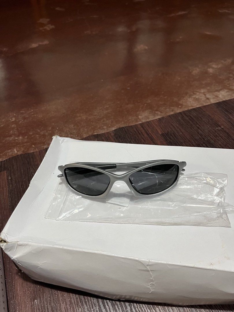 Oakley Plate Sunglasses Y2K Techwear (Category: Sunglasses & Eyewear) located in Manila. Submitted by ljpiastro.031411 (Listing ID 1464814635, Image 1). Description: - Brand: Oakley - Style: Aggressive Y2K wrap-around design - Frame: Durable metallic build with comfortable curved arms - Lenses: Dark lenses for sun protection - Inclusions: Original white packaging box and clear protective storage bag - Condition: Solid build quality, excellent for