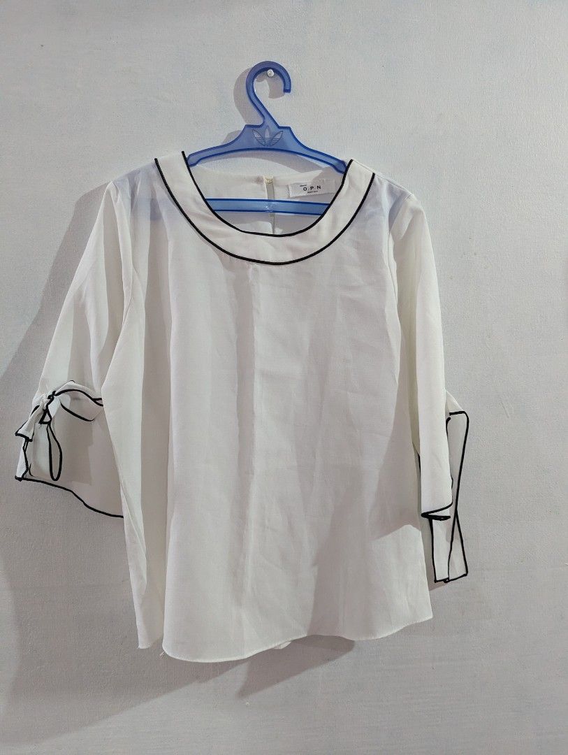 [oppane] O.P.N White Blouse with Black Trim (Category: Blouses) located in Marikina City. Submitted by beybera (Listing ID 1464887865, Image 1). Description: - Brand: oppane O.P.N. (Made in Korea) - Color/Style: White blouse with chic black contrast trim on the round neckline - Details: Short sleeves featuring sweet tied bow accents on both cuffs - Fit: Lightweight, comfortable pullover style - Condition: Clean and well-maintained all around.