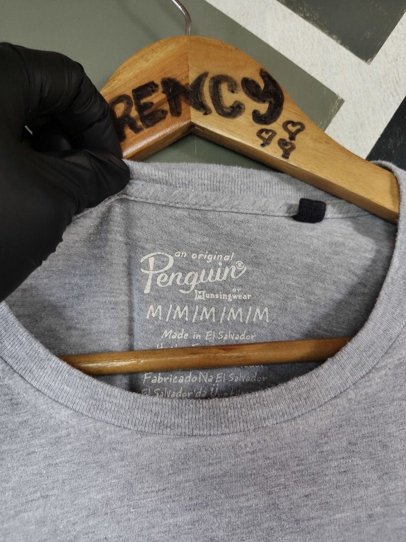 Original Penguin Graphic T-Shirt Gray Medium (Category: Tshirts & Polo Shirts ) located in Manila. Submitted by choycleverdeer.f04b80 (Listing ID 1464927408, Image 2). Description: - Brand: Original Penguin - Size: Medium (M) - Color: Grey - Material: Soft cotton blend - Origin: Made in El Salvador - Design: Unique front graphic featuring a large blue penguin filled with a pool/swimming scene - Details: Signature small penguin logo tab on the lef