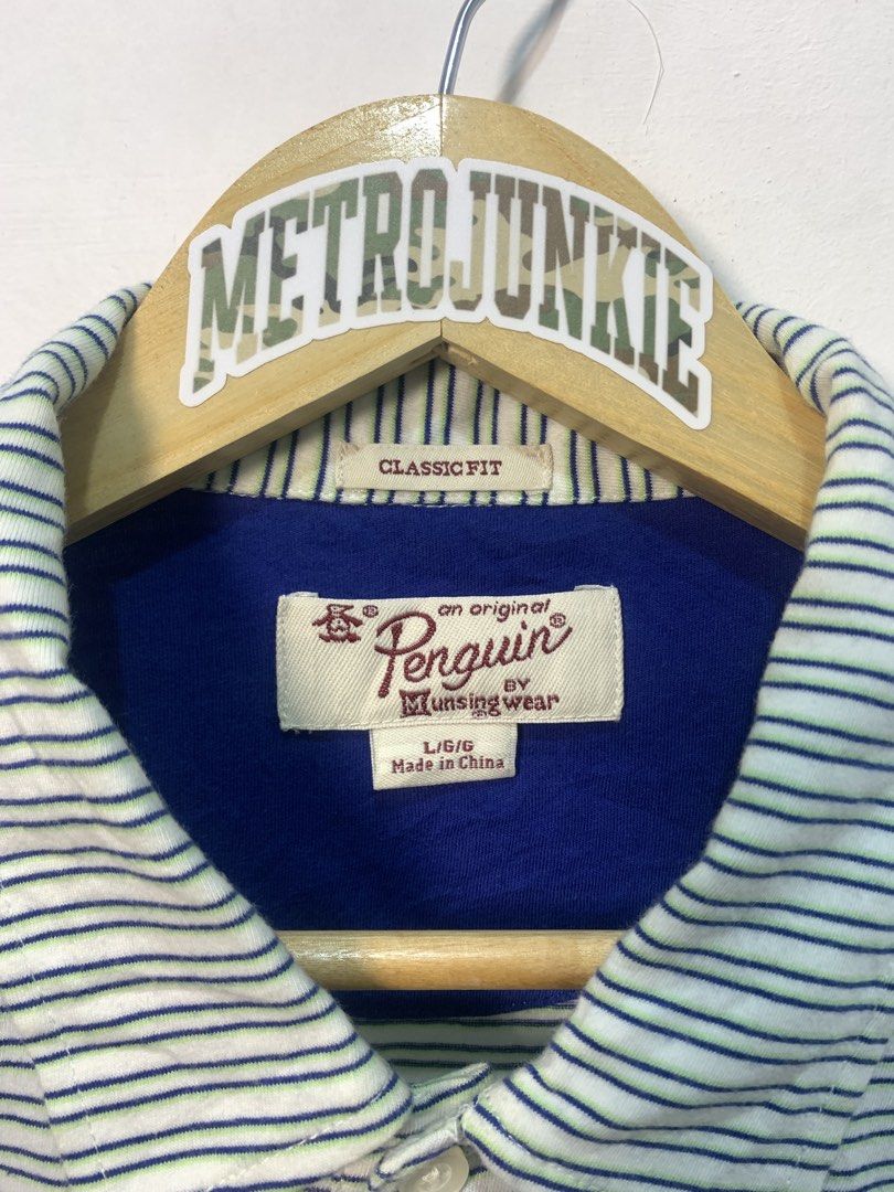 Original Penguin Striped Polo Shirt Size L (Category: Tshirts & Polo Shirts ) located in Davao. Submitted by legitseller1111 (Listing ID 1464771102, Image 3). Description: - Brand: Original Penguin by Munsingwear - Size: Large - Color: White with blue and green horizontal stripes - Fit: Classic fit with standard collar and 3-button placket - Details: Blue contrast inner collar and signature blue embroidered penguin logo on the chest - Origin: Mad