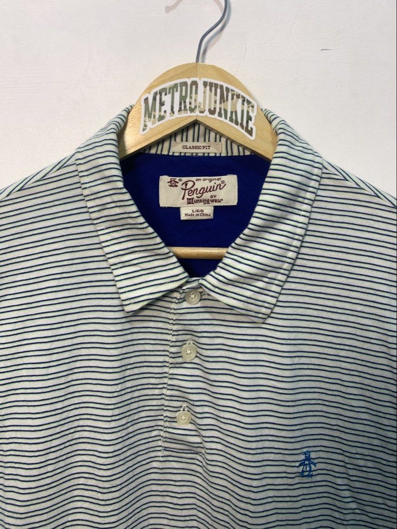 Original Penguin Striped Polo Shirt Size L (Category: Tshirts & Polo Shirts ) located in Davao. Submitted by legitseller1111 (Listing ID 1464771102, Image 2). Description: - Brand: Original Penguin by Munsingwear - Size: Large - Color: White with blue and green horizontal stripes - Fit: Classic fit with standard collar and 3-button placket - Details: Blue contrast inner collar and signature blue embroidered penguin logo on the chest - Origin: Mad