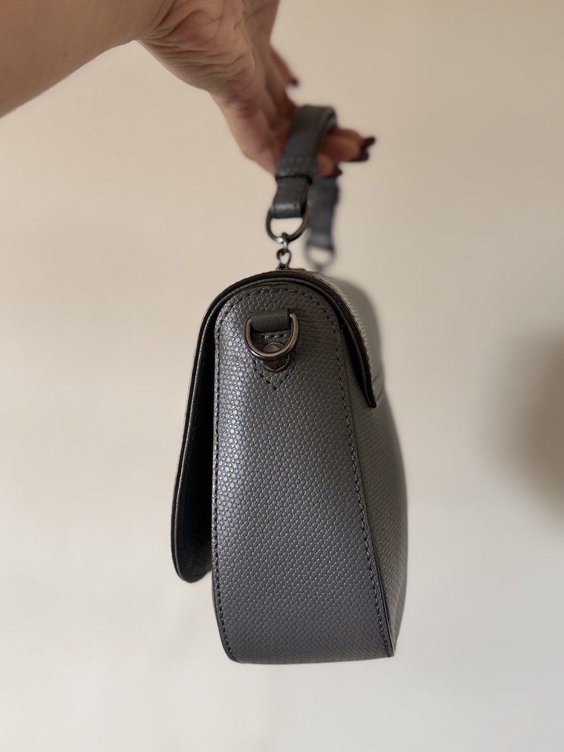 Oryany top handle / cross body bag - Dark Grey (Category: Luxury Bags & Wallets) located in Lipa City. Submitted by asleeeh (Listing ID 1464795551, Image 3). Description: Only used once!! Good as new!! Grey handbag with textured pattern. Structured saddle shape with curved bottom edge. Dark gunmetal hardware including distinctive ornate twist lock closure on front flap. Short top handle attached via rings, plus side rings ready for an optional cr