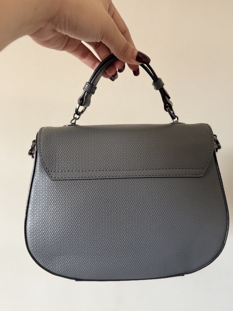 Oryany top handle / cross body bag - Dark Grey (Category: Luxury Bags & Wallets) located in Lipa City. Submitted by asleeeh (Listing ID 1464795551, Image 2). Description: Only used once!! Good as new!! Grey handbag with textured pattern. Structured saddle shape with curved bottom edge. Dark gunmetal hardware including distinctive ornate twist lock closure on front flap. Short top handle attached via rings, plus side rings ready for an optional cr