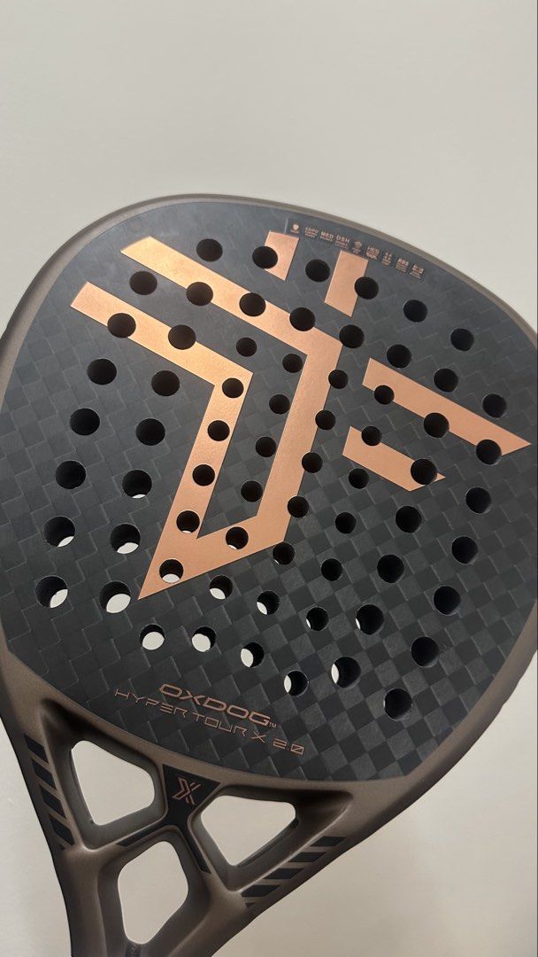 Oxdog Hyper Tour X 2.0 Padel Racket (Category: Racket and Ball Sports) located in Quezon City. Submitted by loi_02 (Listing ID 1464934119, Image 1). Description: - Model: Oxdog Hyper Tour X 2.0 padel racket - Colorway: Sleek black and bronze - Face: Carbon fiber texture with geometric hole pattern and signature branding - Condition: Brand new, unused, and properly stored - Inclusions: Original protective packaging and box included.