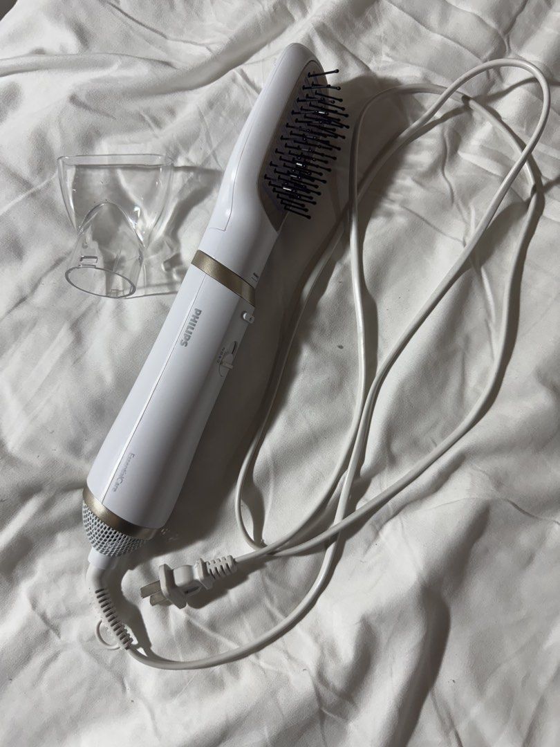 Philips EssentialCare Heated Styling Brush With Attachments (Category: Hair) located in Bacolod City. Submitted by lovedandprelovedbygee (Listing ID 1464845270, Image 2). Description: - Brand: Philips EssentialCare Styling Brush - Color: White with stylish gold accents - Dual Function: Dries and smooths hair simultaneously - Attachments: Includes interchangeable paddle brush and narrow concentrator nozzle - Settings: Convenient multi-speed switch