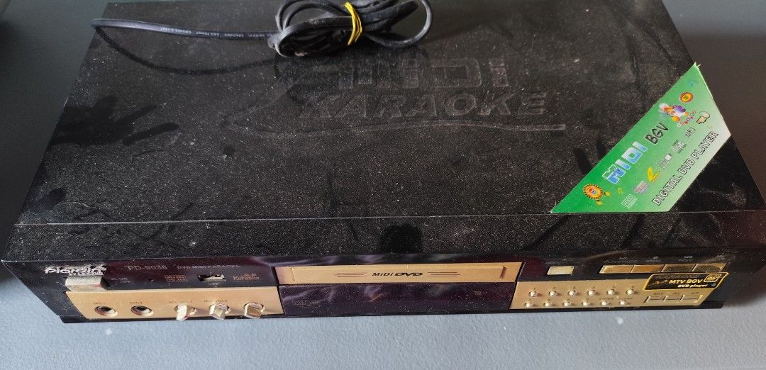 Plardin PD-9038 Midi DVD Karaoke Player (Category: Blu-Ray & Media Players) located in Valenzuela. Submitted by xjepsx (Listing ID 1464815766, Image 2). Description: - Brand/Model: Plardin PD-9038 Digital Karaoke DVD Player - Design: Stylish black chassis with elegant gold accents - Key Features: Dual microphone inputs, front USB port, manual volume knobs, and front number pad buttons - Condition: Good working condition, just needs a quick wipe d