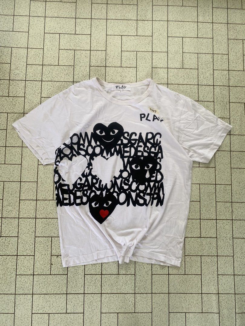 Play Comme des Garcons Graphic White Tee XL (Category: Shirts) located in Manila. Submitted by sepamorash53558 (Listing ID 1464807885, Image 1). Description: - Brand: Play Comme des Garcons - Color: White with black typography and heart graphic - Accent: Signature red heart motif - Size: XL - Material: 100% cotton - Condition: Clean and ready to wear.