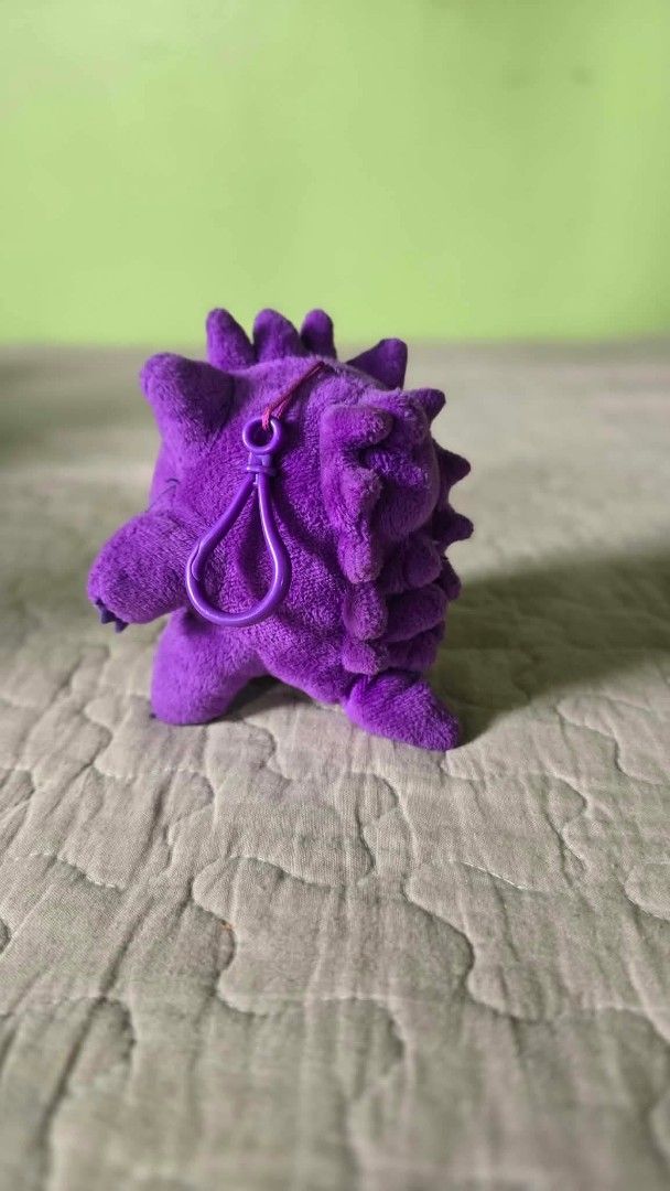 Pokémon Gengar plush keychain purple (Category: Plushies & Soft Toys) located in Baguio. Submitted by je_ver_lyn16 (Listing ID 1464843598, Image 2). Description: - Item: Gengar plush keychain 3rd round korea exclusive - Material: Soft purple fabric with embroidered red eyes and stitched white grin - Attachment: Durable purple plastic clip on the back - Authenticity/Origin: Tag reads '3rd Round Made in China' - Condition: Excellent, clean, no stai