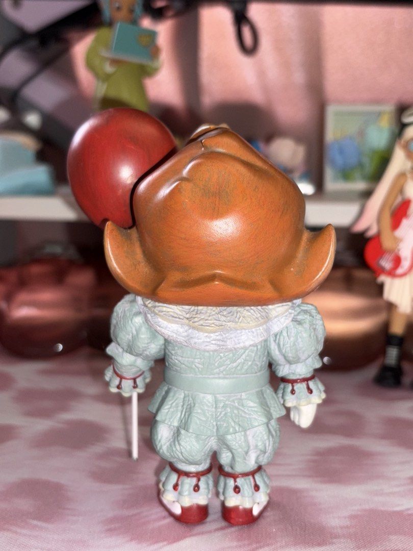 Popmart Molly IT Mini Figure (Category: Figurines & Statues) located in Manila. Submitted by donnaburde79462 (Listing ID 1464793435, Image 2). Description: - Detailed Pennywise figurine holding its signature red balloon - Features a greyish-green clown suit with ruffles, orange hair, and flower-patterned yellow eyes - Stands on its own without needing a support base - Excellent, clean condition, previously displayed on a shelf.