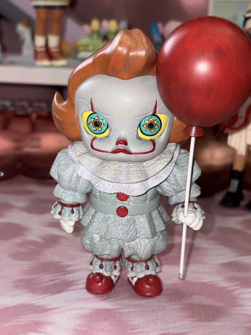 Popmart Molly IT Mini Figure (Category: Figurines & Statues) located in Manila. Submitted by donnaburde79462 (Listing ID 1464793435, Image 1). Description: - Detailed Pennywise figurine holding its signature red balloon - Features a greyish-green clown suit with ruffles, orange hair, and flower-patterned yellow eyes - Stands on its own without needing a support base - Excellent, clean condition, previously displayed on a shelf.