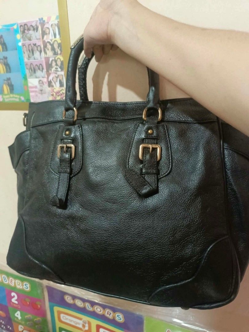 Prada Black Leather Handbag (Category: Luxury Bags & Wallets) located in Manila. Submitted by dei03_diz (Listing ID 1464942750, Image 2). Description: - Authentic black textured leather Prada handbag - Elegant gold-tone hardware and iconic Prada triangle logo - Dual top handles and stylish front buckle straps - Spacious black Prada jacquard fabric interior - Includes an interior zipper pocket and leather logo patch - Perfect, roomy everyday shoul