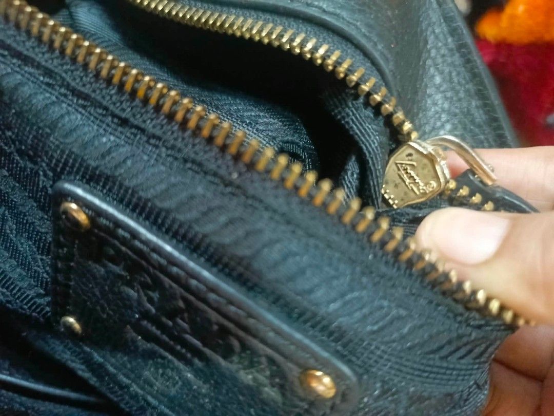 Prada Black Leather Handbag (Category: Luxury Bags & Wallets) located in Manila. Submitted by dei03_diz (Listing ID 1464942750, Image 3). Description: - Authentic black textured leather Prada handbag - Elegant gold-tone hardware and iconic Prada triangle logo - Dual top handles and stylish front buckle straps - Spacious black Prada jacquard fabric interior - Includes an interior zipper pocket and leather logo patch - Perfect, roomy everyday shoul