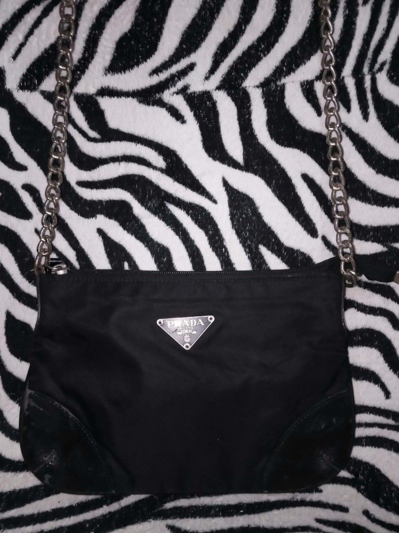 Prada Black Nylon Chain Shoulder Bag (Category: Luxury Bags & Wallets) located in Valenzuela. Submitted by rowenasalvador777 (Listing ID 1464968279, Image 1). Description: - Authentic black nylon Prada shoulder bag - Iconic enamel triangle logo on the front - Elegant silver hardware and comfortable chain strap - Secure top zipper closure - Durable leather-reinforced bottom corners - Roomy interior for your daily essentials - 100% Guaranteed authe