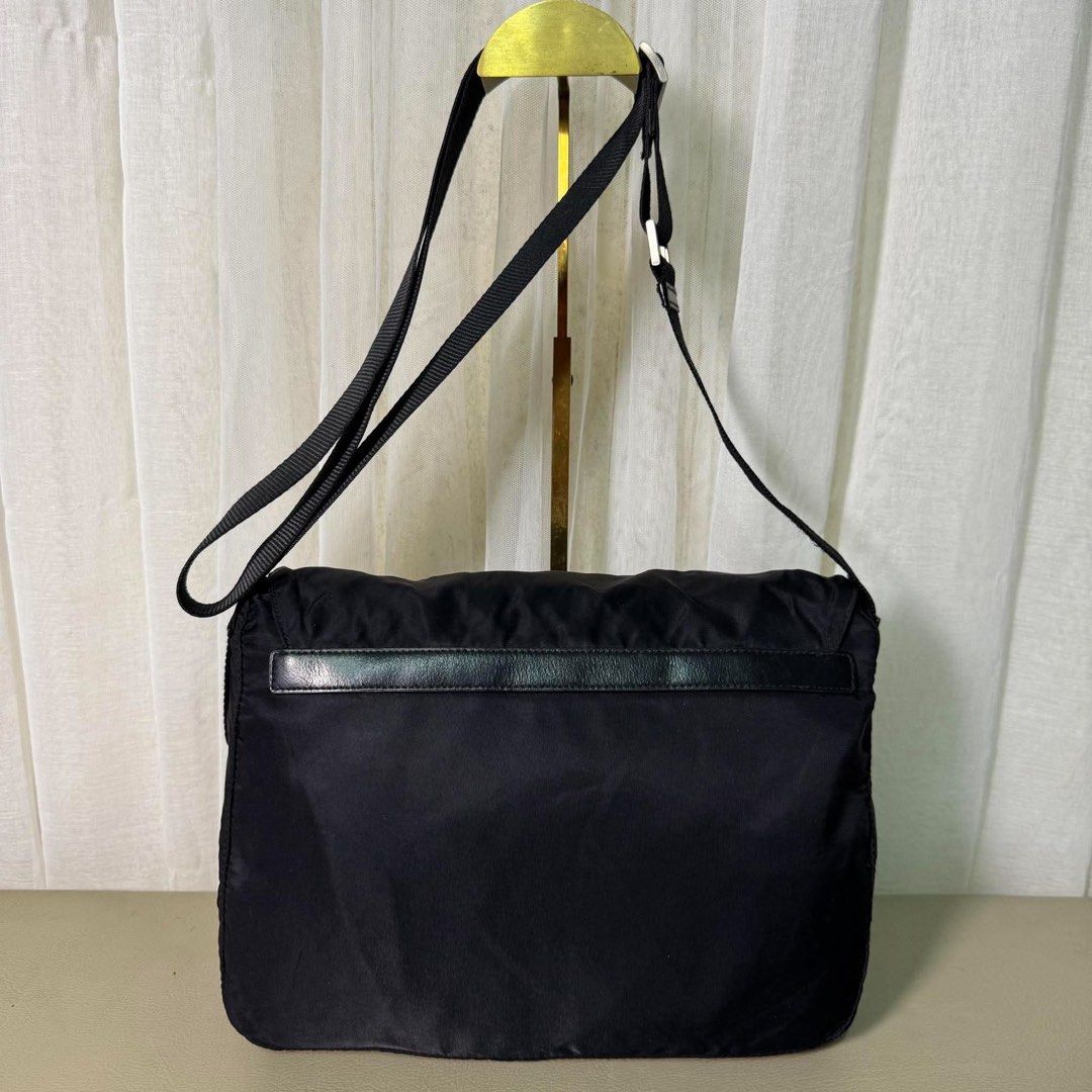 Prada Black Nylon Messenger Bag with Leather Straps (Category: Luxury Bags & Wallets) located in Madrid. Submitted by jhunaceee (Listing ID 1464892670, Image 2). Description: - Authentic Prada messenger bag in classic black durable nylon - Iconic triangular Prada logo plaque on the front - Front flap closure with stylish dual leather straps and metal buckles - Handy exterior zippered pocket for quick-access items - Adjustable fabric shoulder stra