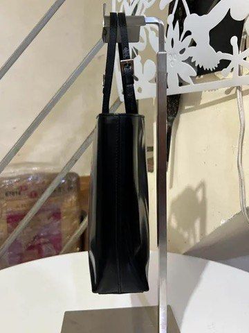 Prada Black Patent Leather Tote Handbag (Category: Purses & Pouches) located in Quezon City. Submitted by luxuriesbymichiika (Listing ID 1464942953, Image 3). Description: - Authentic Prada black patent leather tote bag - Glossy finish with sleek silver-tone hardware - Double thin shoulder straps with adjustable buckles - Structured square silhouette with clean stitching - Minimalist white Prada logo stamped near the top corner - Spacious interio
