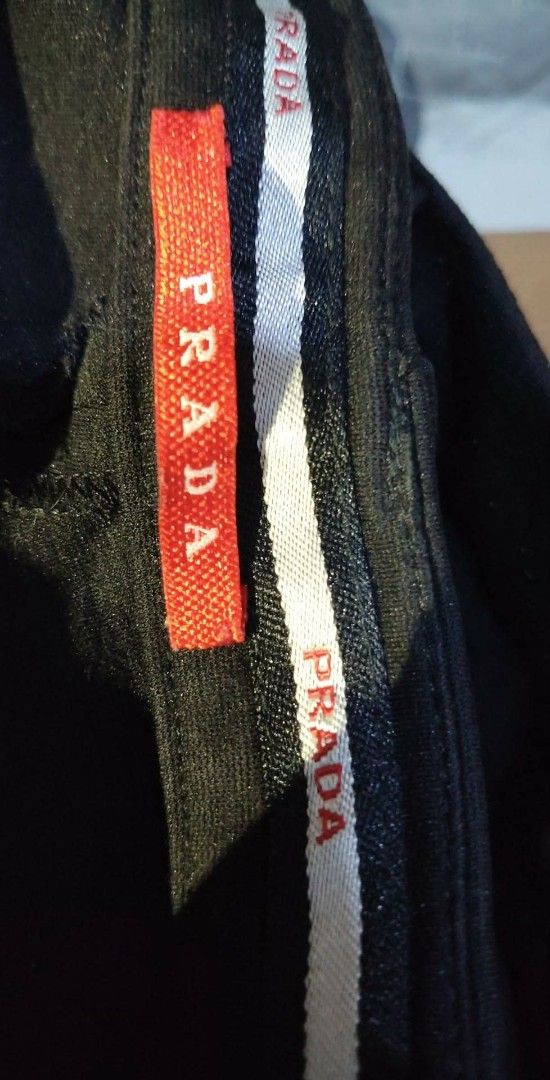 Prada Black Technical Pants (Category: Jeans) located in Aborlan. Submitted by mysticstone_a8589f (Listing ID 1464899263, Image 3). Description: - Brand: Prada - Color: Classic Black - Fit: Modern slim cut with stretchy fabric for maximum comfort - Pockets: Secure zipper pockets on both front hips and back - Details: Prada branding printed near the back pocket and embroidered inside the waistband - Authenticity: Features iconic red Prada fabric t