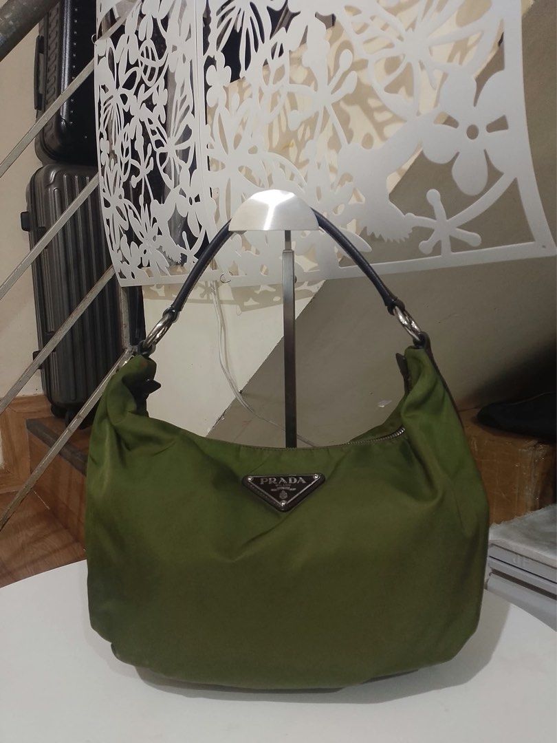 Prada Olive Green Nylon Hobo Shoulder Bag (Category: Luxury Bags & Wallets) located in Quezon City. Submitted by luxuriesbymichiika (Listing ID 1464898009, Image 1). Description: - Brand: Prada - Material: Durable nylon in olive green with dark brown Saffiano leather strap and side panels - Hardware: Silver-tone with secure zipper closure - Details: Iconic triangular metal Prada logo plaque on the front - Shape: Classic, slouchy hobo silhouette -