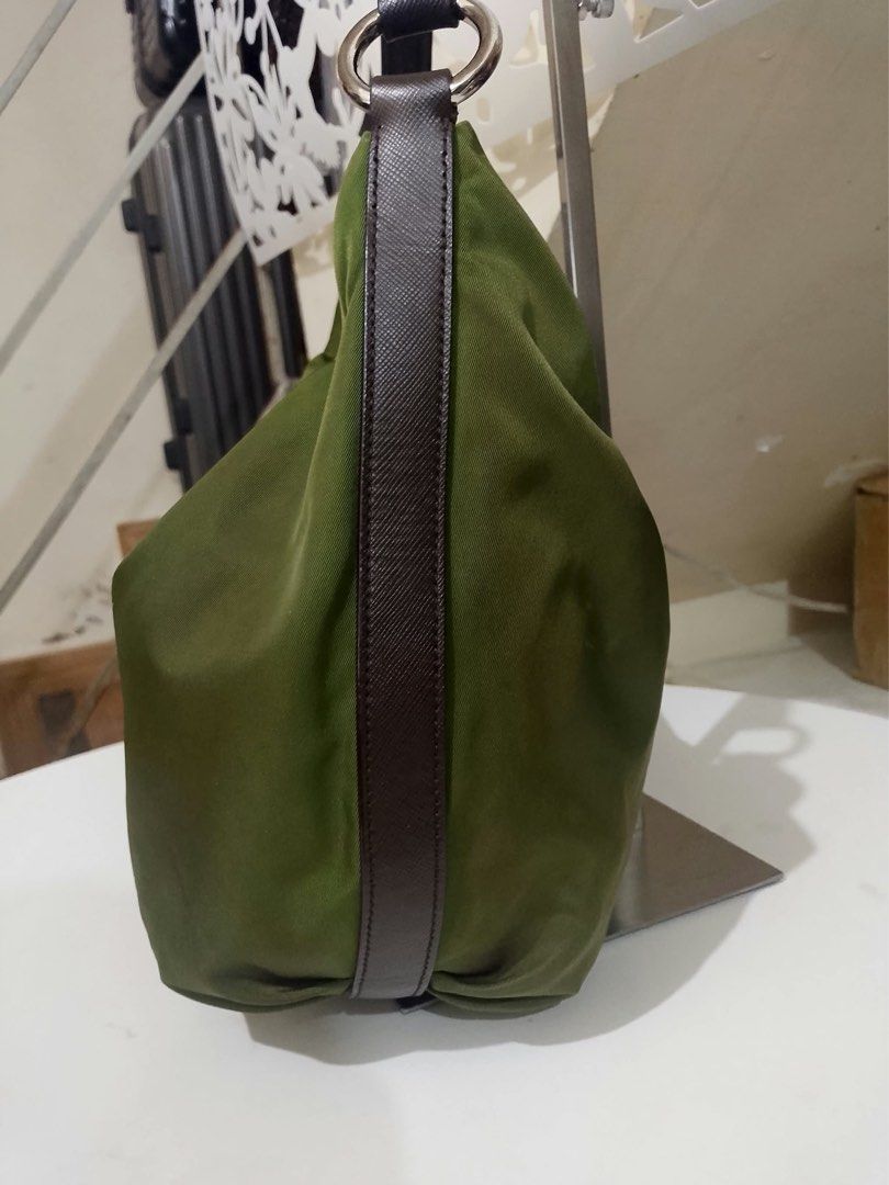 Prada Olive Green Nylon Hobo Shoulder Bag (Category: Luxury Bags & Wallets) located in Quezon City. Submitted by luxuriesbymichiika (Listing ID 1464898009, Image 3). Description: - Brand: Prada - Material: Durable nylon in olive green with dark brown Saffiano leather strap and side panels - Hardware: Silver-tone with secure zipper closure - Details: Iconic triangular metal Prada logo plaque on the front - Shape: Classic, slouchy hobo silhouette -