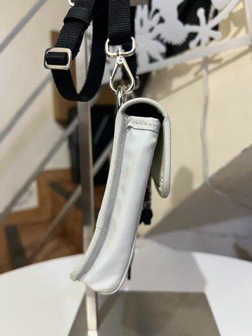 Prada White Re-Nylon Crossbody Bag (Category: Luxury Bags & Wallets) located in Quezon City. Submitted by luxuriesbymichiika (Listing ID 1464902731, Image 3). Description: - Authentic white Prada Re-Nylon crossbody bag - Premium Saffiano leather trim and silver-tone hardware - Secure front flap closure with buckle and back clear ID slot - Adjustable black strap for comfortable wear - Includes original dust bag, presentation box, and authenticity 