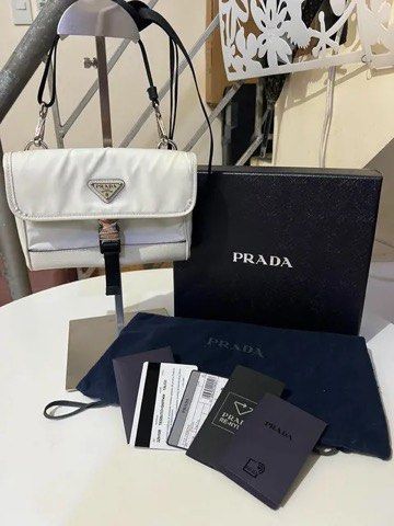 Prada White Re-Nylon Crossbody Bag (Category: Luxury Bags & Wallets) located in Quezon City. Submitted by luxuriesbymichiika (Listing ID 1464902731, Image 1). Description: - Authentic white Prada Re-Nylon crossbody bag - Premium Saffiano leather trim and silver-tone hardware - Secure front flap closure with buckle and back clear ID slot - Adjustable black strap for comfortable wear - Includes original dust bag, presentation box, and authenticity 