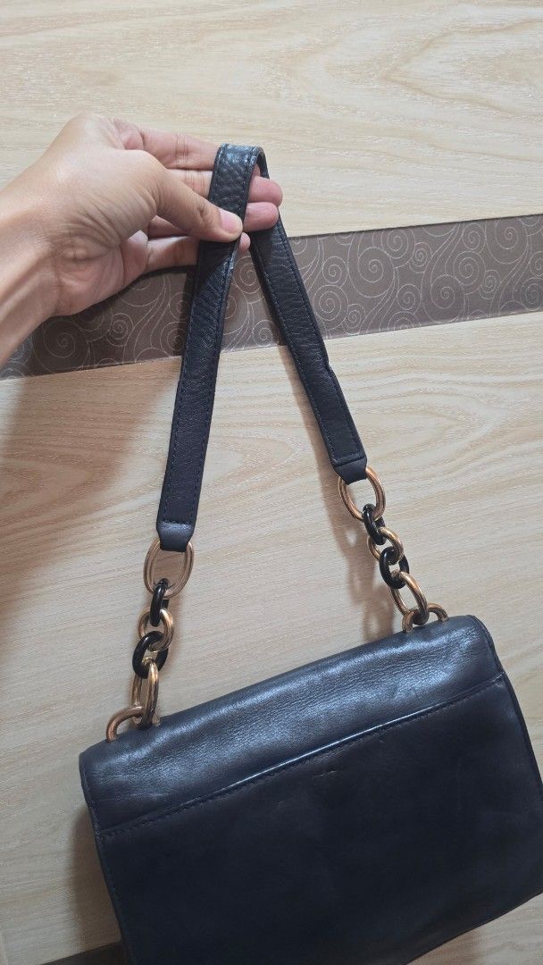 Preloved Michael Kors Leather Shoulder Bag with Chain Strap (Category: Luxury Bags & Wallets) located in Quezon City. Submitted by mbpreloved65 (Listing ID 1464863865, Image 3). Description: - Brand: Michael Kors - Color/Material: Black leather - Closure: Front flap with gold-tone hardware and dark accent plate - Strap: Unique chain and leather design - Interior: Roomy main compartment - Condition: Normal wear on hardware and leather surface.