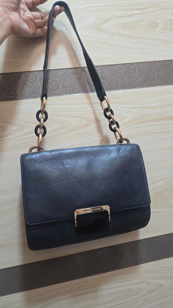 Preloved Michael Kors Leather Shoulder Bag with Chain Strap (Category: Luxury Bags & Wallets) located in Quezon City. Submitted by mbpreloved65 (Listing ID 1464863865, Image 1). Description: - Brand: Michael Kors - Color/Material: Black leather - Closure: Front flap with gold-tone hardware and dark accent plate - Strap: Unique chain and leather design - Interior: Roomy main compartment - Condition: Normal wear on hardware and leather surface.
