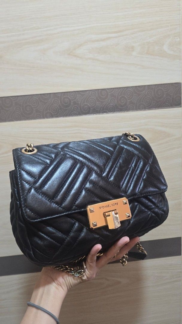 Preloved Michael Kors Quilted Black Leather Shoulder Bag (Category: Luxury Bags & Wallets) located in Quezon City. Submitted by mbpreloved65 (Listing ID 1464863513, Image 2). Description: - Brand: Michael Kors - Material: Black quilted leather with gold hardware - Strap: Elegant gold chain strap - Closure: Secure front flap with turn-lock - Interior: Signature black monogram lining with a convenient zipper pocket - Size: Perfect for carrying dail
