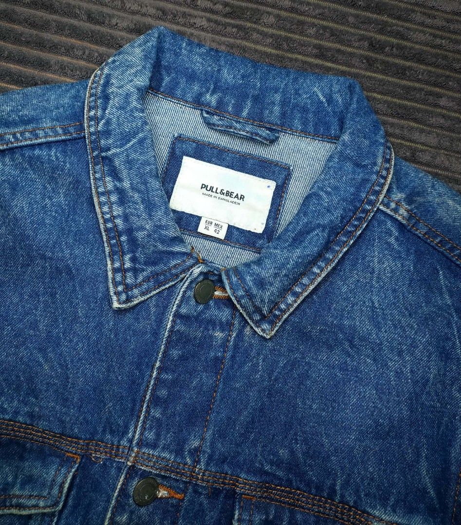 Pull & Bear Denim Jacket Size XL (Category: Coats, Jackets and Outerwear) located in Manila. Submitted by norathrifted (Listing ID 1464791547, Image 3). Description: - Brand: Pull & Bear - Size: XL / MEX 42 - Material: Sturdy cotton denim - Origin: Made in Bangladesh - Design: Heavy acid wash vintage finish - Features: Button-up front with metal buttons, chest flap pockets, and side pockets - Condition: Ready to wear.