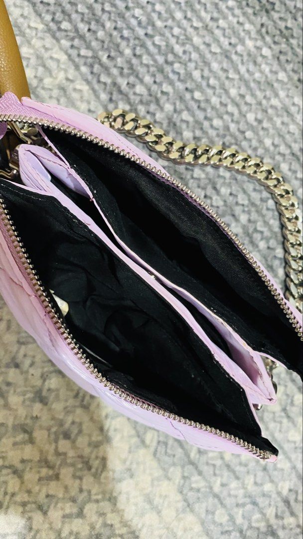 Quilted Light Purple Chain Shoulder Bag (Category: Shoulder Bags) located in Santiago. Submitted by kjuvieann39 (Listing ID 1464803612, Image 3). Description: - Color: Light purple with subtle front logo stamp - Design: Quilted diamond stitching with soft padded material - Hardware: Trendy chunky silver-tone chain strap - Closure: Secure top zip closure - Interior: Black fabric lining with multiple compartments for organization - Size: Compact an