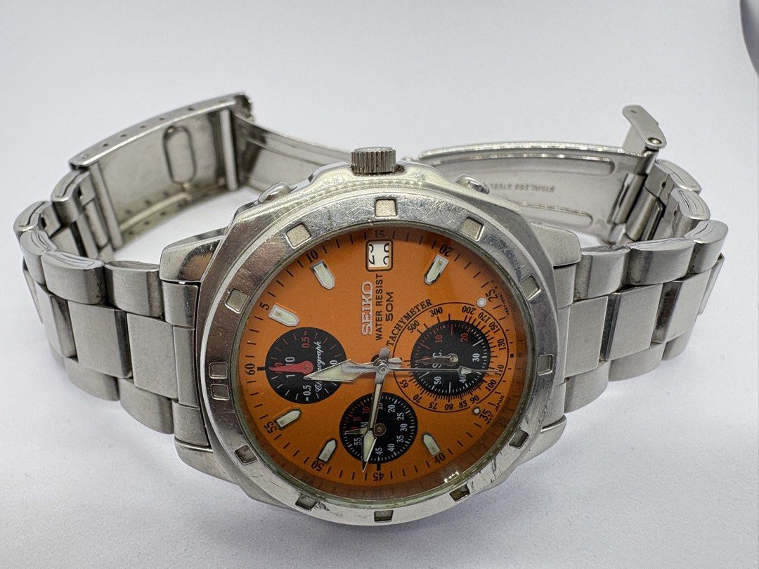 Rare Seiko Chronograph Orange Dial Watch (Category: Men's Watches) located in Quezon City. Submitted by rentoti (Listing ID 1464795572, Image 2). Description: - Brand/Model: Seiko Chronograph - Dial: Vibrant orange with three sub-dials and date window at 3 o'clock - Bezel: Tachymeter bezel - Case & Bracelet: Stainless steel case with matching metal bracelet - Case Back: Engraved with Seiko branding, serial number 831140, and 5 bar water resistanc