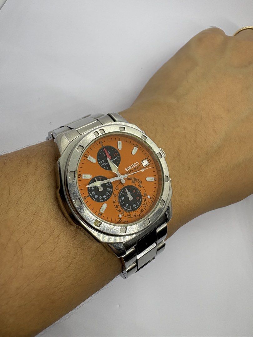 Rare Seiko Chronograph Orange Dial Watch (Category: Men's Watches) located in Quezon City. Submitted by rentoti (Listing ID 1464795572, Image 3). Description: - Brand/Model: Seiko Chronograph - Dial: Vibrant orange with three sub-dials and date window at 3 o'clock - Bezel: Tachymeter bezel - Case & Bracelet: Stainless steel case with matching metal bracelet - Case Back: Engraved with Seiko branding, serial number 831140, and 5 bar water resistanc